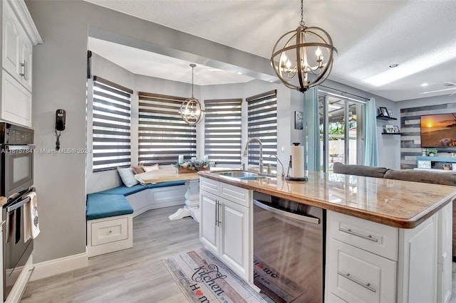 kitchen featuring a center island with sink, appliances with stainless steel finishes, white cabinets, and a healthy amount of sunlight