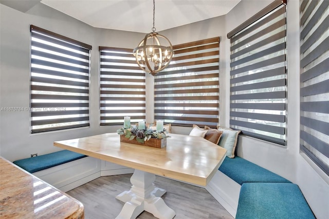 dining space with a chandelier, breakfast area, and light wood-type flooring