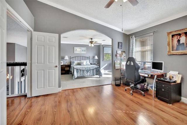 office space featuring ornamental molding, a textured ceiling, light wood-type flooring, and ceiling fan