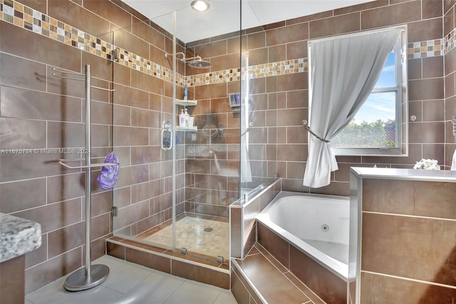 bathroom featuring shower with separate bathtub, tile walls, and tile patterned flooring