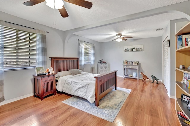 bedroom with a closet, ceiling fan, and light hardwood / wood-style flooring