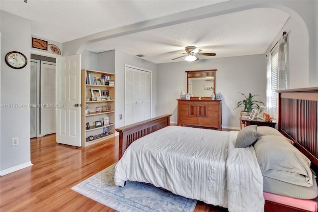 bedroom featuring light hardwood / wood-style floors, a textured ceiling, and ceiling fan