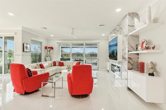 tiled living room with ceiling fan and ornamental molding