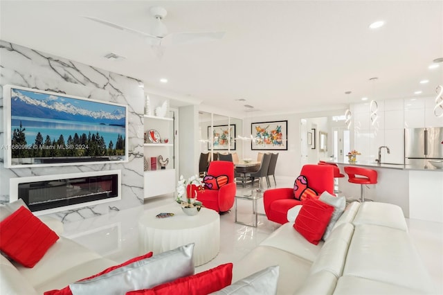 living room with a premium fireplace and ceiling fan