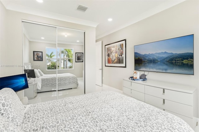 bedroom with a closet, ornamental molding, and light tile patterned floors