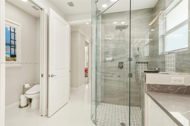 bathroom with tile patterned floors, a shower with shower door, and toilet