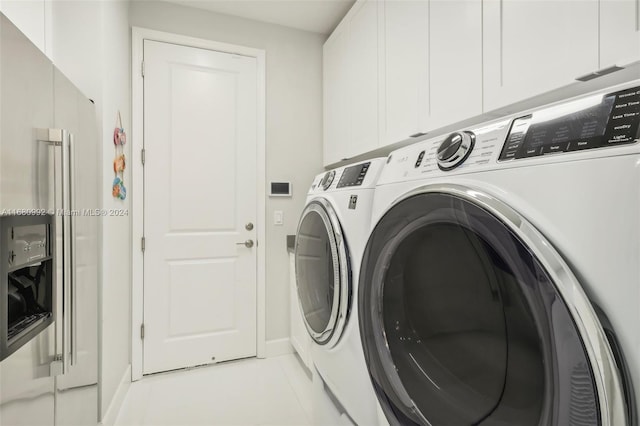 laundry room featuring cabinets, washing machine and clothes dryer, and light tile patterned floors