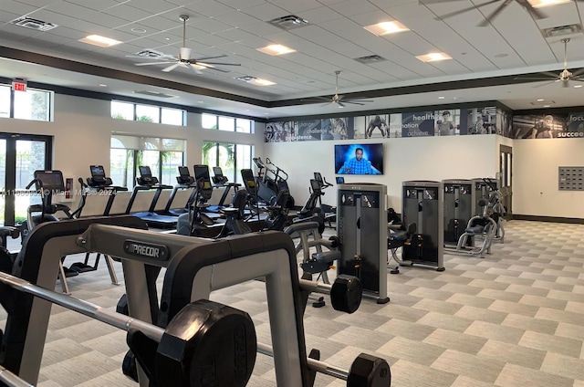 workout area featuring light carpet and a paneled ceiling