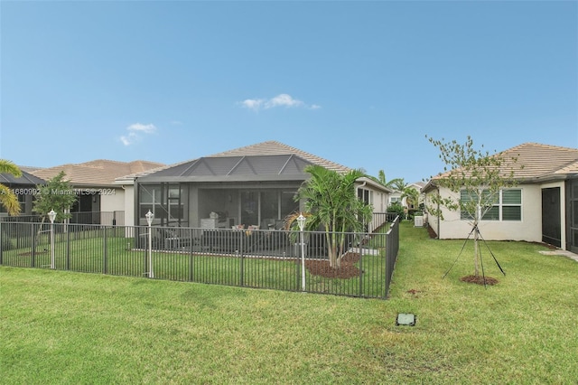 rear view of property with a yard and a sunroom