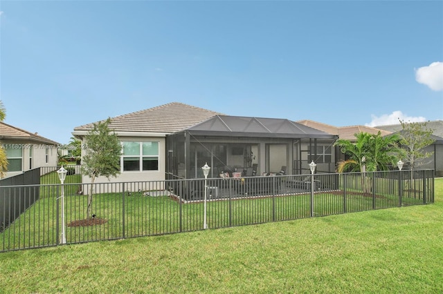 rear view of property featuring a lanai and a lawn