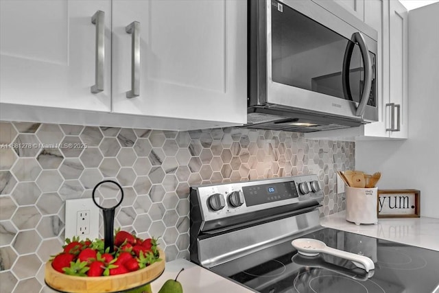 kitchen featuring stainless steel appliances, tasteful backsplash, and white cabinets