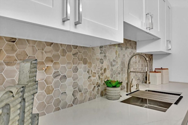 kitchen featuring white cabinetry, sink, and decorative backsplash