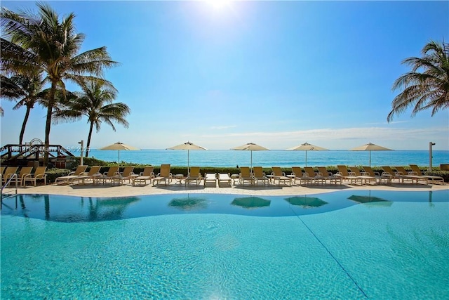 view of swimming pool with a patio and a water view