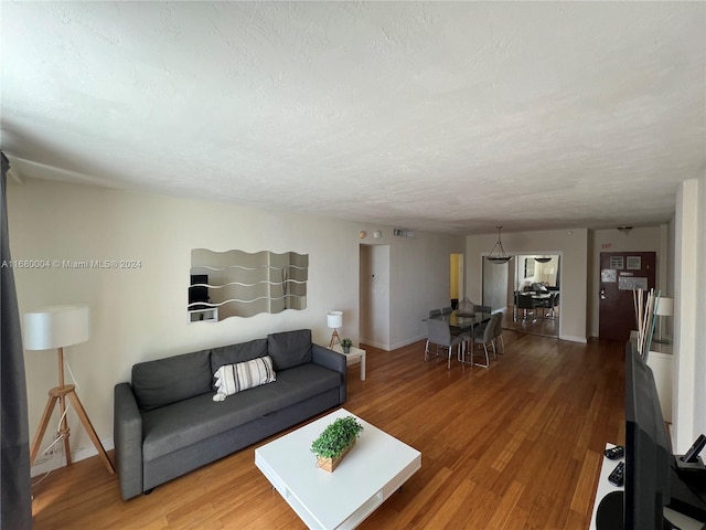 living room featuring wood-type flooring and a textured ceiling