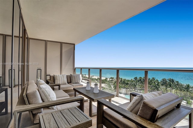 balcony featuring a view of the beach, a water view, and outdoor lounge area