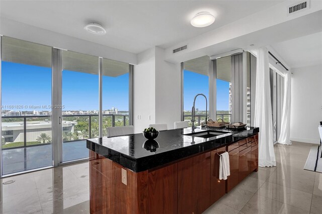 kitchen featuring wall chimney range hood, tasteful backsplash, decorative light fixtures, and a kitchen bar