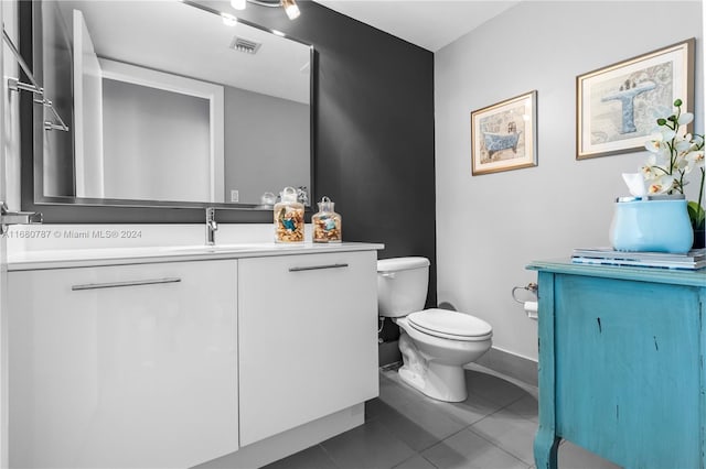 bathroom featuring vanity, tile patterned floors, and toilet