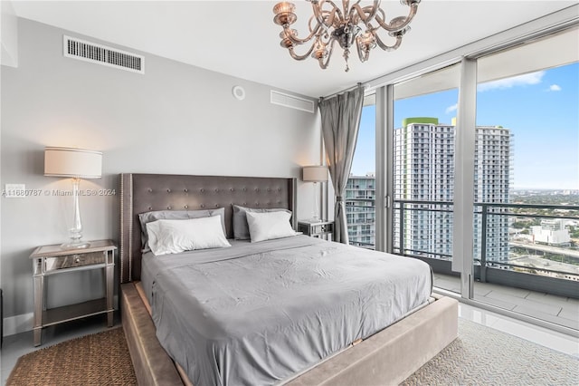 bedroom featuring access to exterior, expansive windows, and a chandelier