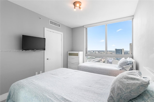 bedroom featuring multiple windows and floor to ceiling windows