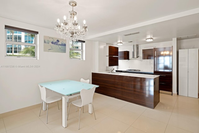 tiled dining room with a chandelier and sink