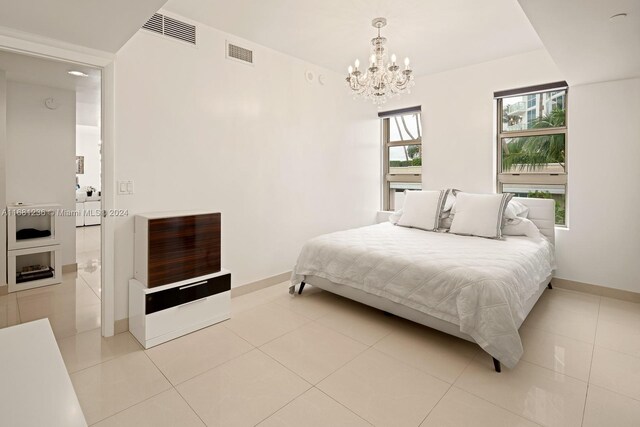 bedroom with a notable chandelier and light tile patterned floors