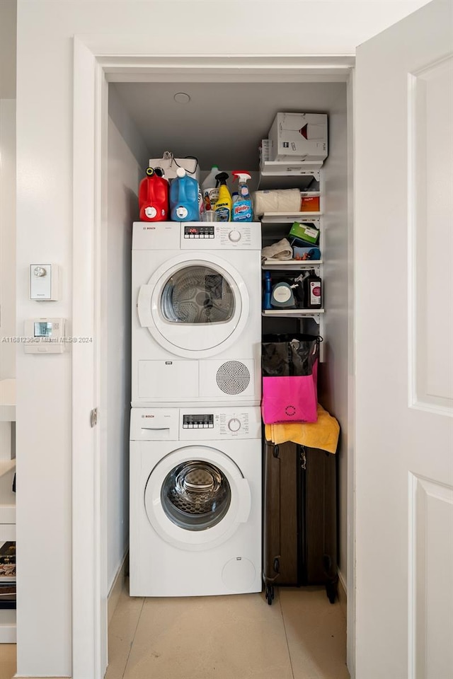 washroom featuring light tile patterned floors and stacked washer and clothes dryer