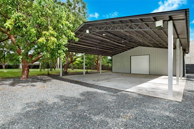 view of car parking featuring a yard, a garage, and a carport