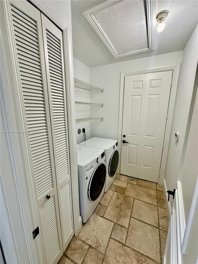 washroom with independent washer and dryer and a textured ceiling