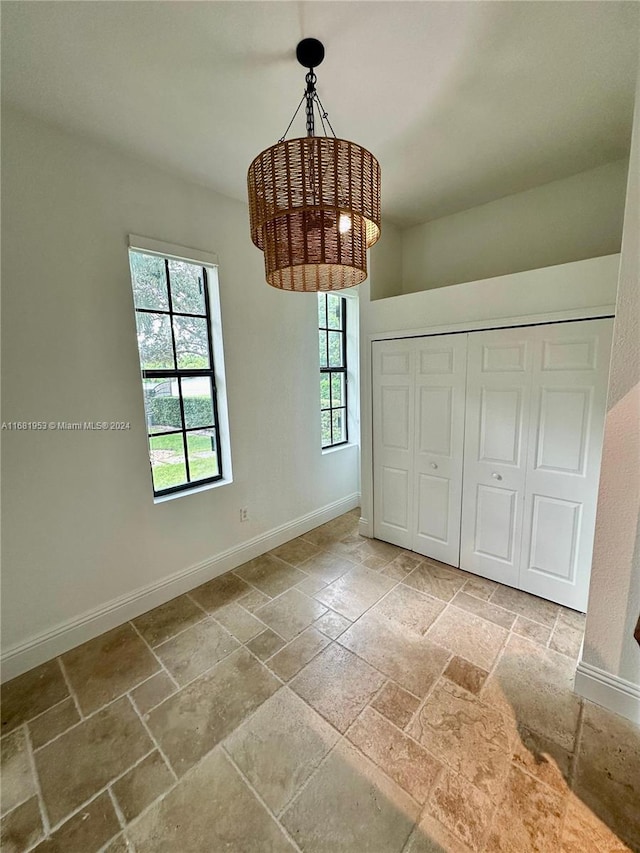 unfurnished dining area with a chandelier