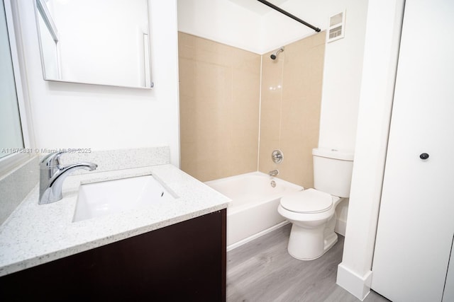 full bathroom featuring toilet, hardwood / wood-style flooring, vanity, and tiled shower / bath