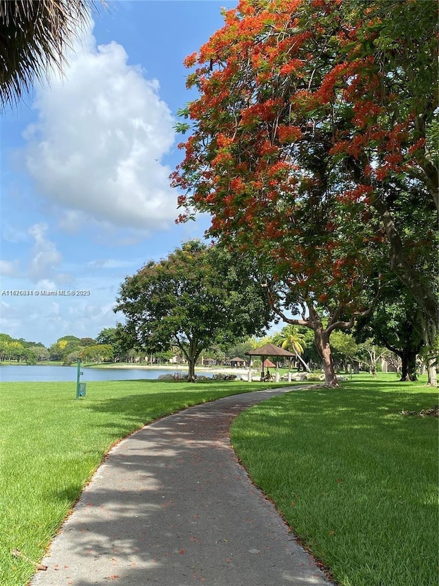 surrounding community with a yard and a water view