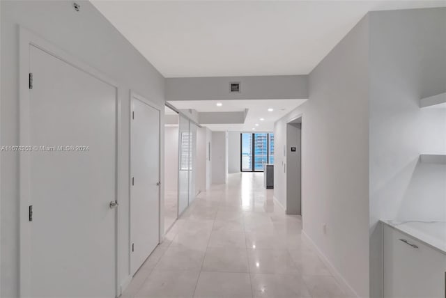 hall with light tile patterned floors