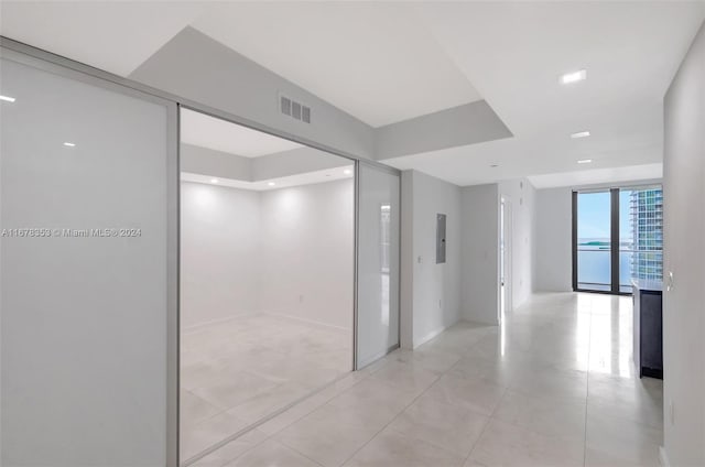 corridor featuring expansive windows and light tile patterned floors