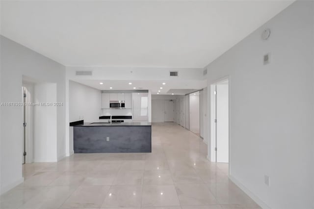 kitchen featuring sink, kitchen peninsula, and white cabinets