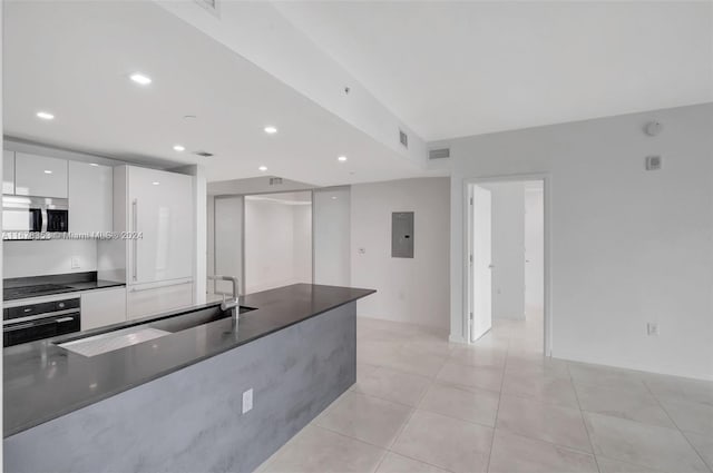 kitchen featuring light tile patterned floors, black cooktop, stainless steel oven, white cabinetry, and electric panel