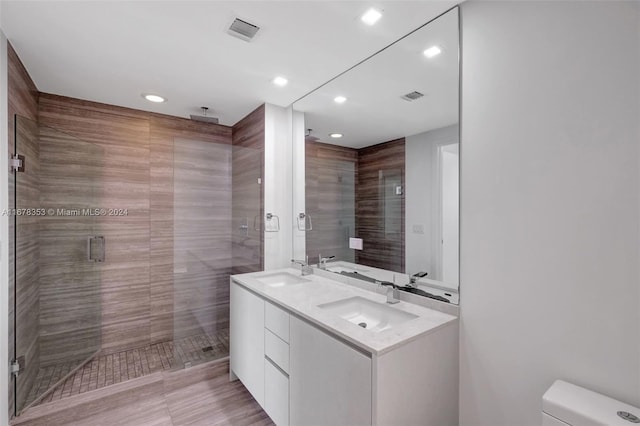 bathroom with vanity, toilet, and a shower with shower door