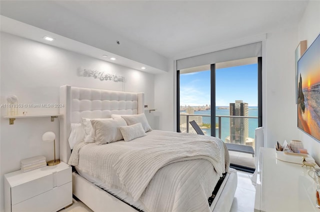 bedroom featuring a water view and light tile patterned flooring