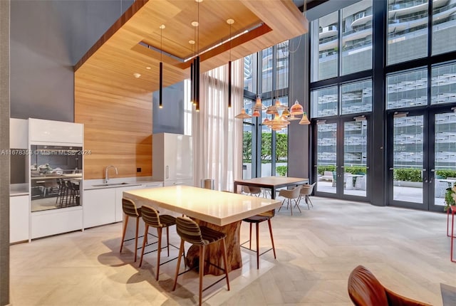 dining room with sink, a high ceiling, french doors, and wooden ceiling