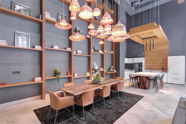 dining room featuring sink and a high ceiling