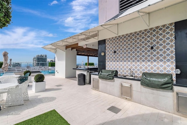 view of patio with sink, an outdoor kitchen, and grilling area