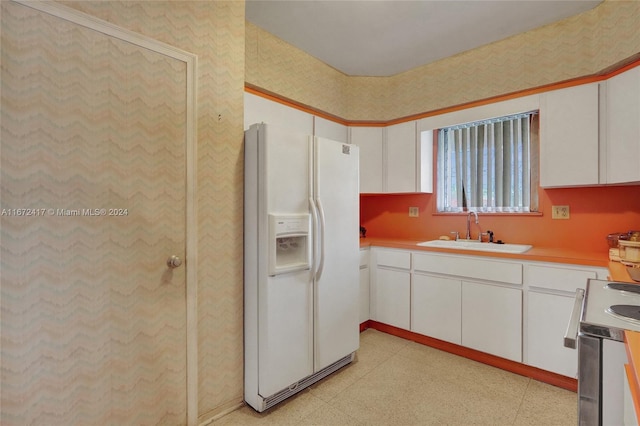 kitchen with sink, white cabinets, and white fridge with ice dispenser