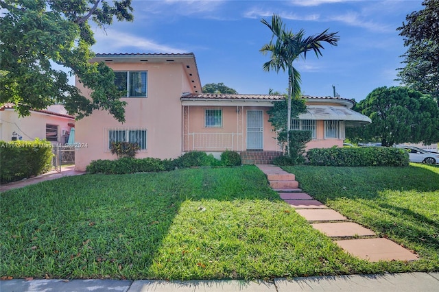 mediterranean / spanish home featuring a front lawn