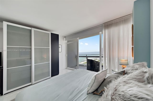 bedroom featuring a water view and access to outside