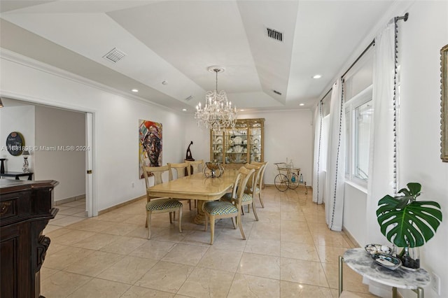 tiled dining space featuring a notable chandelier, ornamental molding, and a raised ceiling