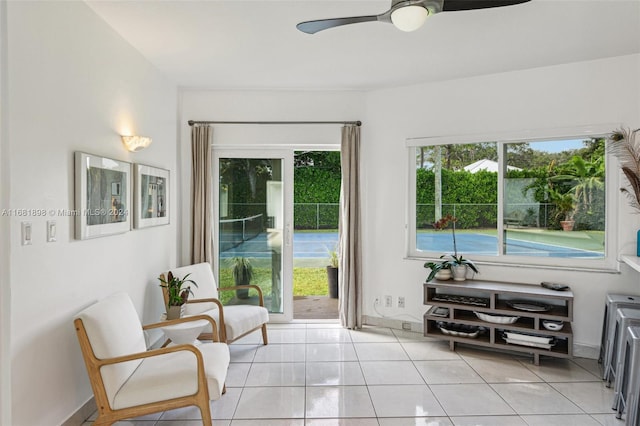 living area featuring ceiling fan and light tile patterned flooring