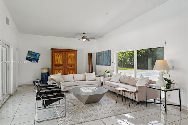 living room featuring vaulted ceiling, light tile patterned flooring, and ceiling fan