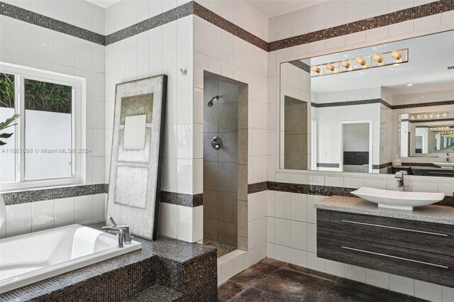 bathroom with vanity, a healthy amount of sunlight, tile walls, and independent shower and bath