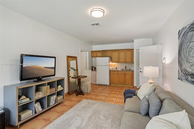 living room featuring sink and light tile patterned floors