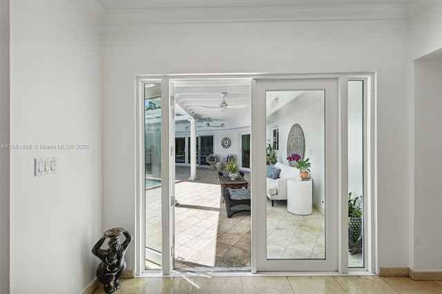 doorway to outside featuring ceiling fan and ornamental molding