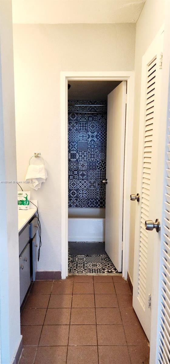 hallway featuring dark tile patterned flooring